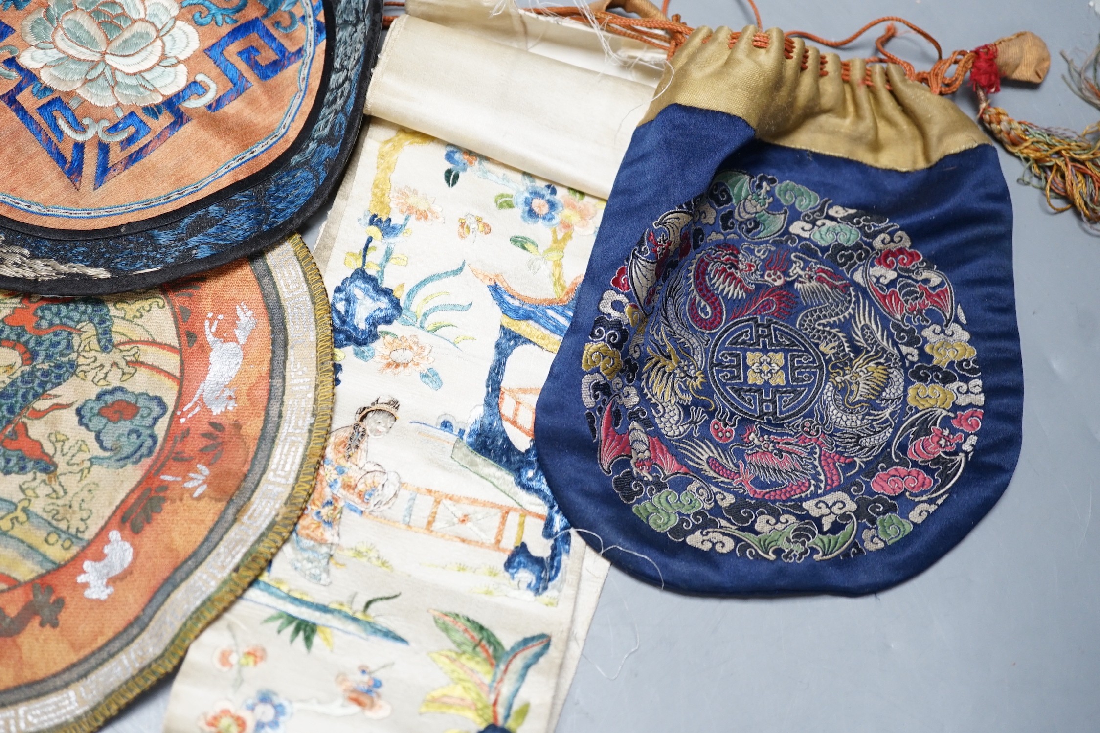 A Chinese embroidered sleeve band, two mats and a woven brocade bag.